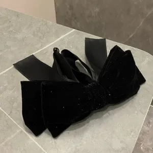 Black velvet bow hair clip with subtle glitter, elegant vintage claw clip accessory for women.