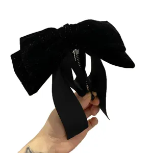 Elegant black velvet bow hair claw clip with long ribbons, perfect for half-up hairstyles.