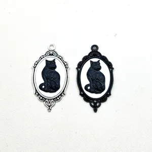 Detalle de primeros planos de colgantes de camafeo de gato negro gótico en metal plateado.