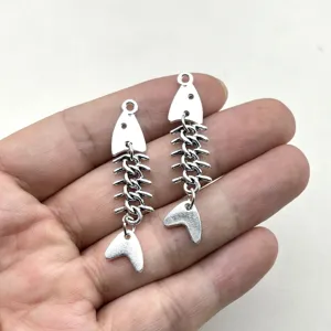 Nahaufnahme von silbernen Fischgräten Metallanhängern, detailliertes DIY Schmuck Zubehör.