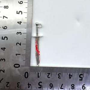 Detailansicht des DIY-Schwertanhängers mit rotem Öl für handgemachte Ohrringe und Schmuckteile.