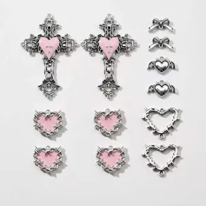 Detailansicht von DIY Gothic Metallanhängern mit rosa Herzanhängern und süssen Schleifen.