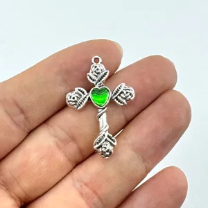 Nahaufnahme Detail des Vintage gotischen Dornen Rose Kreuz Anhängers mit grünem Herz Zubehör.
