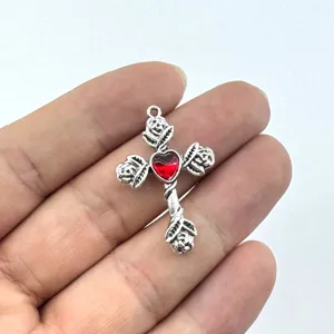 Detaillierte Nahaufnahme des Vintage Gotik Kreuz Anhängers mit rotem Herz und Rosen.