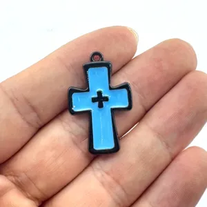 Nahaufnahme des gotischen blauen Kreuzanhängers mit schwarzem Rand, Metallschmuck Detail.
