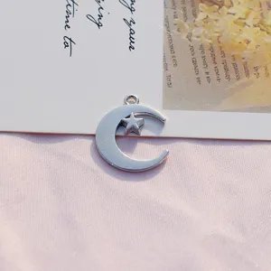 Primer plano detallado de un colgante de metal plateado de luna y estrella, ideal.