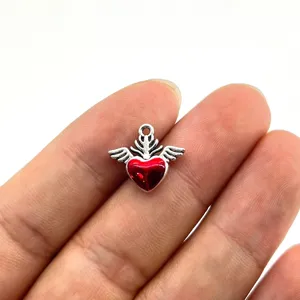 Primo piano pendente in lega di metallo con cuore rosso e ali per collana fai da te.