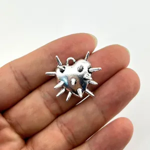 Close-up view of silver thorn heart metal pendant showing detailed punk gothic style DIY charm.