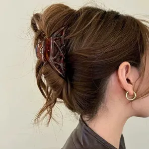 Closeup of tortoiseshell geometric hair claw clip detail, elegant retro hair accessory.