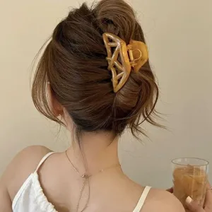 Detail shot of an elegant amber geometric hair claw clip, perfect for stylish French updos.