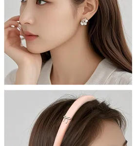Exquisite floral clover earrings and stylish pink satin bow narrow headband detail close-up.