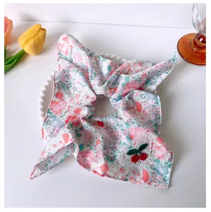 Close-up detail of a cute pink floral square scarf scrunchie with a sweet cherry lace patch.