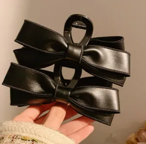 Detailed view of the large black PU leather bow hair claw clip, elegant and simple design.