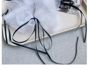 Franse balletstijl witte organza haarscrunchie met lange zwarte linten en elegante haaraccessoires.