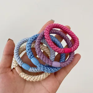 Close-up detail of colorful braided hair ties with smooth connecting beads. Elastic and soft.