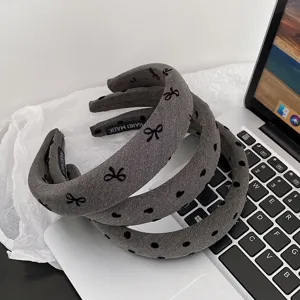 Grey wide padded headband with cute bow patterns, stylish hair accessory for daily wear.