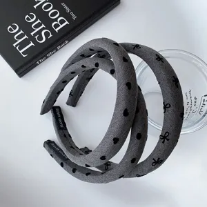 Grey wide padded hair hoop with cute black bow and heart prints for women daily fashion style.