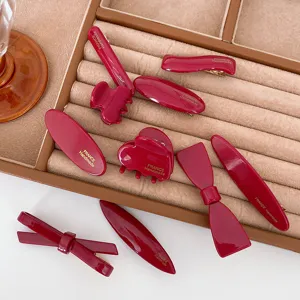 Detailed view of wine red handmade resin hair clips, featuring elegant bow and claw designs.