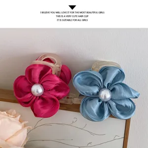 Detailaufnahme niedlicher Stoffblumen-Haarklammern mit Perlen in Rosa und Blau, idealer Haarschmuck.