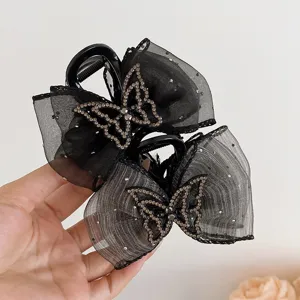 Primer plano detalle del pasador de pelo mariposa strass malla negra accesorio elegante fino.