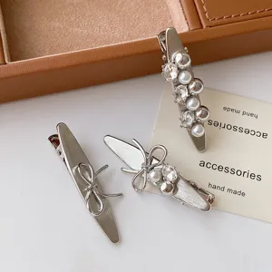 Detailed view of silver metallic bow and pearl rhinestone hair clips, stylish daily hair accessories.