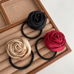 Detailed view of handmade satin rose flower hair ties, elegant hair accessories in three colors.