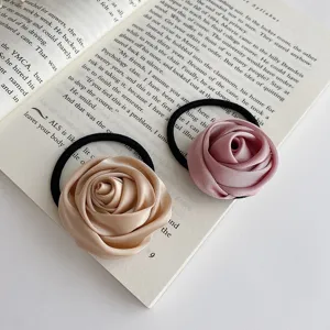 Detail view of stylish fabric rose flower hair ties in champagne and pink, perfect for daily wear.