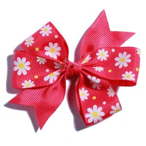 Detailed view of a red grosgrain bow hair accessory with charming white daisy pattern