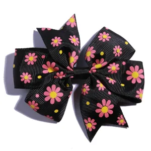 Detail view of the pink daisy floral print on a black ribbed ribbon hair bow