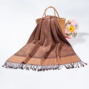 Close-up of brown pashmina scarf featuring intricate paisley jacquard and tassel details
