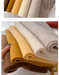 Macro view of premium wool scarves in warm earthy tones showing soft texture and fringe.