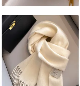 Detailed close-up of a 100% Australian wool cream scarf showing soft texture and label