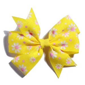 Detailed view of yellow daisy print grosgrain bow hair clip with ribbed texture