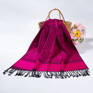 Detailed view of magenta paisley jacquard pashmina scarf with elegant black tassels