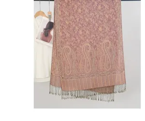 Primer plano de una bufanda rosa con jacquard de cachemira y borlas decorativas