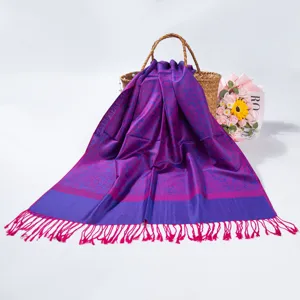 Macro view of purple paisley jacquard pashmina scarf featuring elegant fringe trim details
