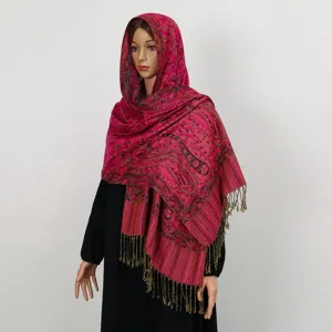 Vista detallada de un elegante chal de jacquard paisley rosa con flecos en un maniquí
