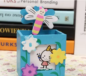 Detalle de portalápices de madera lindo, clip de insecto y marco de foto de escritorio.