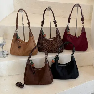 Vue détaillée de sacs portés épaule rétro en suède montrant diverses couleurs et styles.
