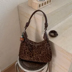 Détail de gros plan du sac bandoulière hobo léopard marron vintage avec une poignée nouée.