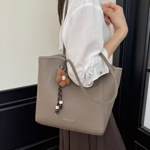 Graue lässige Damen Schultertasche Detailansicht mit süßem Blumenanhänger und großem Stauraum.
