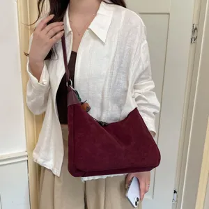 Vue détaillée du sac porté épaule hobo en suédine bordeaux rétro avec texture souple.