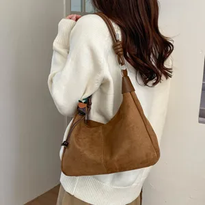 Sac porté épaule marron en suédine avec bandoulière nouée et design boulette rétro.