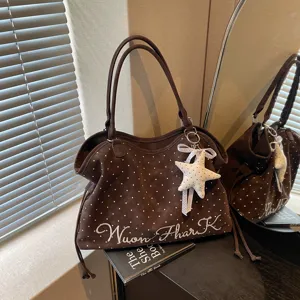 Brown polka dot tote bag detail view, stylish shoulder bag with star pendant for women.