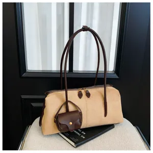 Detail view of the stylish suede underarm shoulder bag with dual handles and mini charm.