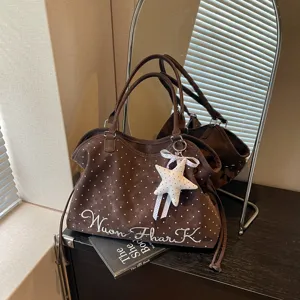Detailed view of brown polka dot tote bag with star charm and embroidery, daily style.