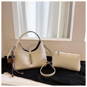Detailed view of beige textured leather hobo shoulder bag with metal lock and matching pouch.