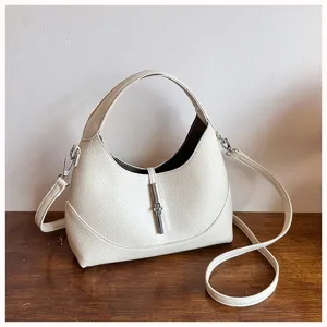 Close-up detail view of the white hobo shoulder bag featuring a metallic lock closure.