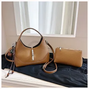 Detail view of brown hobo dumpling shoulder bag with metallic lock closure and matching pouch.