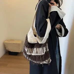 Detail view of the stylish knit fringe shoulder bag in brown and beige stripes for autumn.